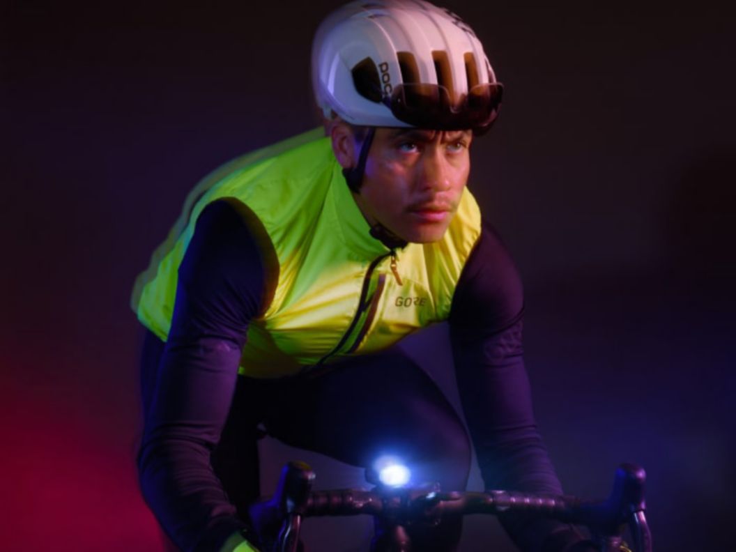 A rider in the dark wearing high-vis riding apparel while using a handlebar mounted front light.